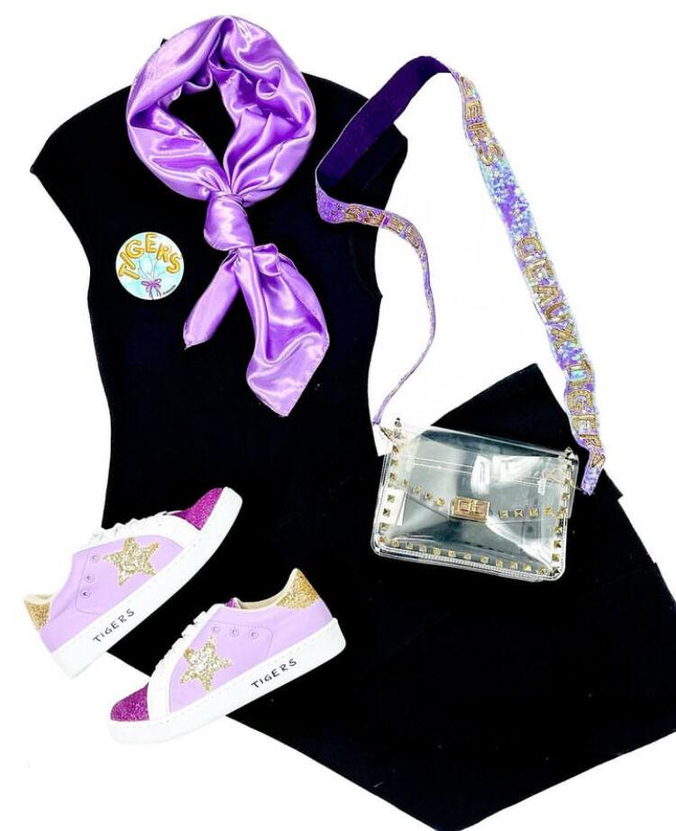 <p>A black midi dress paired with purple and gold accessories represents many of the current gameday fashion trends.</p>