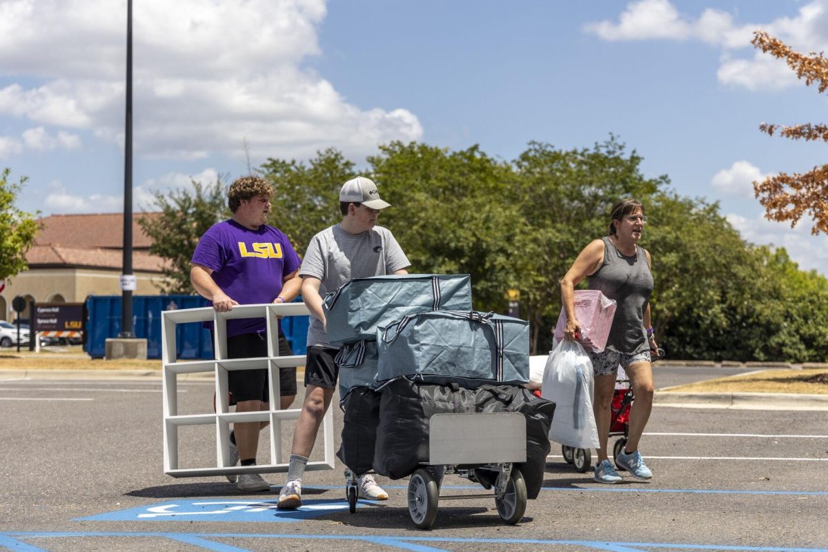 A student is assisted by his family with Move-In Day Saturday, Aug. 12, 2023, outside Spruce Hall on LSU's campus.