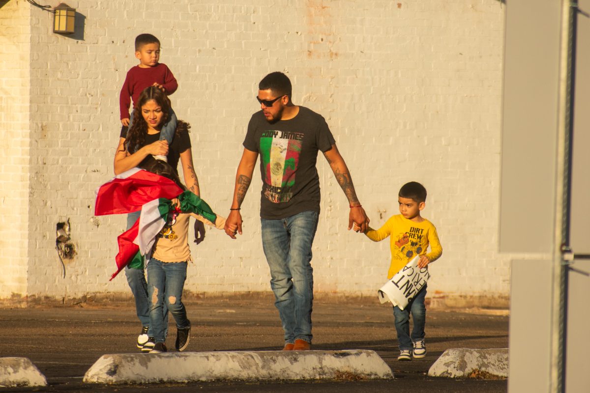 A family demonstrates against mass deportation, holding signs and flags Sunday, Feb. 2, 2025, at Convention Street and River Road in downtown Baton Rouge, La.