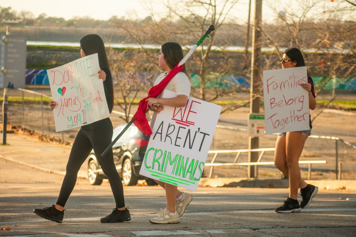 Protesters grip signs calling for immigration reform during a demonstration against mass deportation Sunday, Feb. 2, 2025, at Convention Street and River Road in downtown Baton Rouge, La.