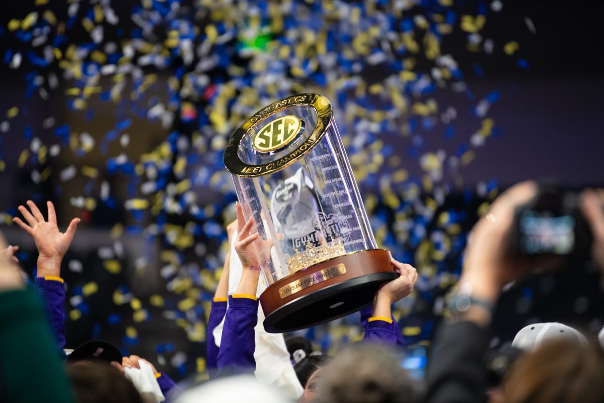 LSU gymnastics members hold up the SEC Championship Trophy after LSU's win on Saturday, March 22, 2025, at the Legacy Arena in Birmingham, Al.