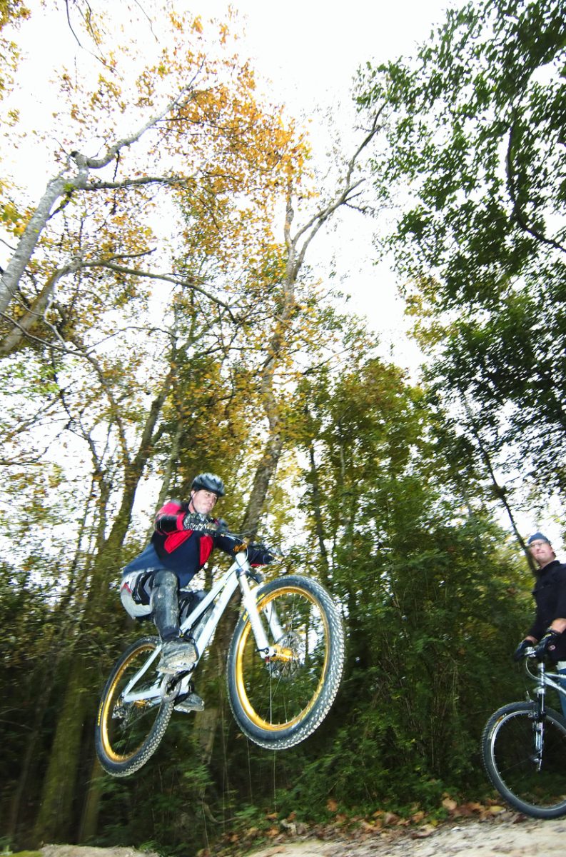 Baton Rouge, Louisiana - 2017: A man jumps on his mountain bike on a trail at the Comite River Park