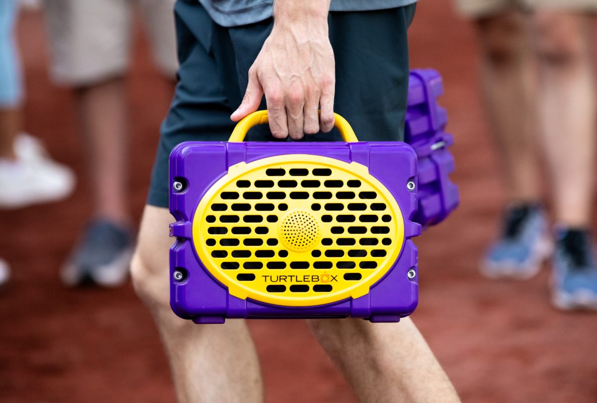LSU baseball junior right-handed pitcher Gavin Guidry (8) carries a speaker on the field during practice for the Men’s College World Series Thursday, June 12, 2025, at Charles Schwab Field on Mike Fahey Street in Omaha, Ne.