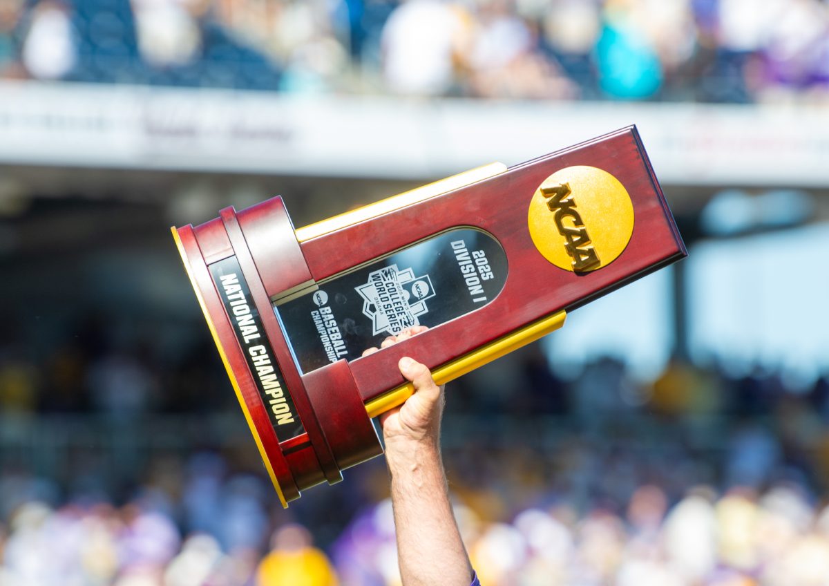 An LSU baseball player holds up the trophy after winning the Men’s College World Series Sunday, June 22, 2025, at Charles Schwab Field in Omaha, Ne.