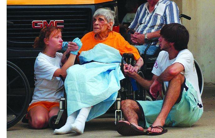 Two LSU student volunteers comfort an evacuee from New Orleans as she waits to board a bus outside the PMAC on Tuesday, Aug. 30, 2005.