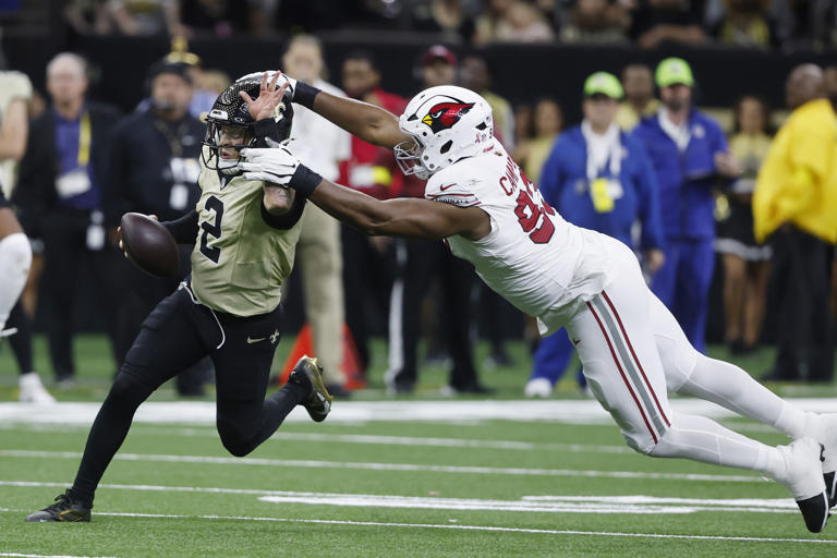 New Orleans Saints quarterback Spencer Rattler (2) tries to run past Arizona Cardinals defensive tackle Calais Campbell during the second half of an NFL football game Sunday, Sept. 7, 2025, in New Orleans. 