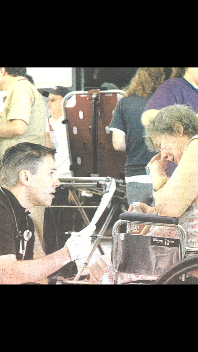 Dr. Ron Coe questions an elderly evacuee in the PMAC on Aug. 31, 2005.