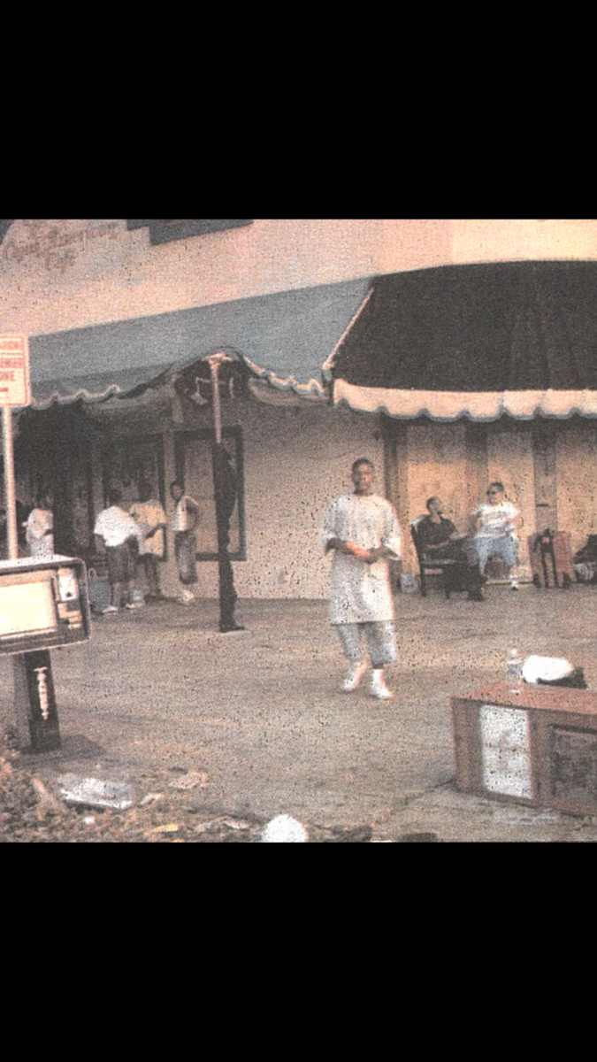 New Orleans residents sit outside a boarded-up Copeland’s Restaurant on the corner of Napoleon and St. Charles on Sept. 4, 2005.