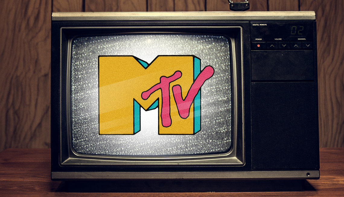 a tv from the eighties on a desk in a wood paneled room with sta