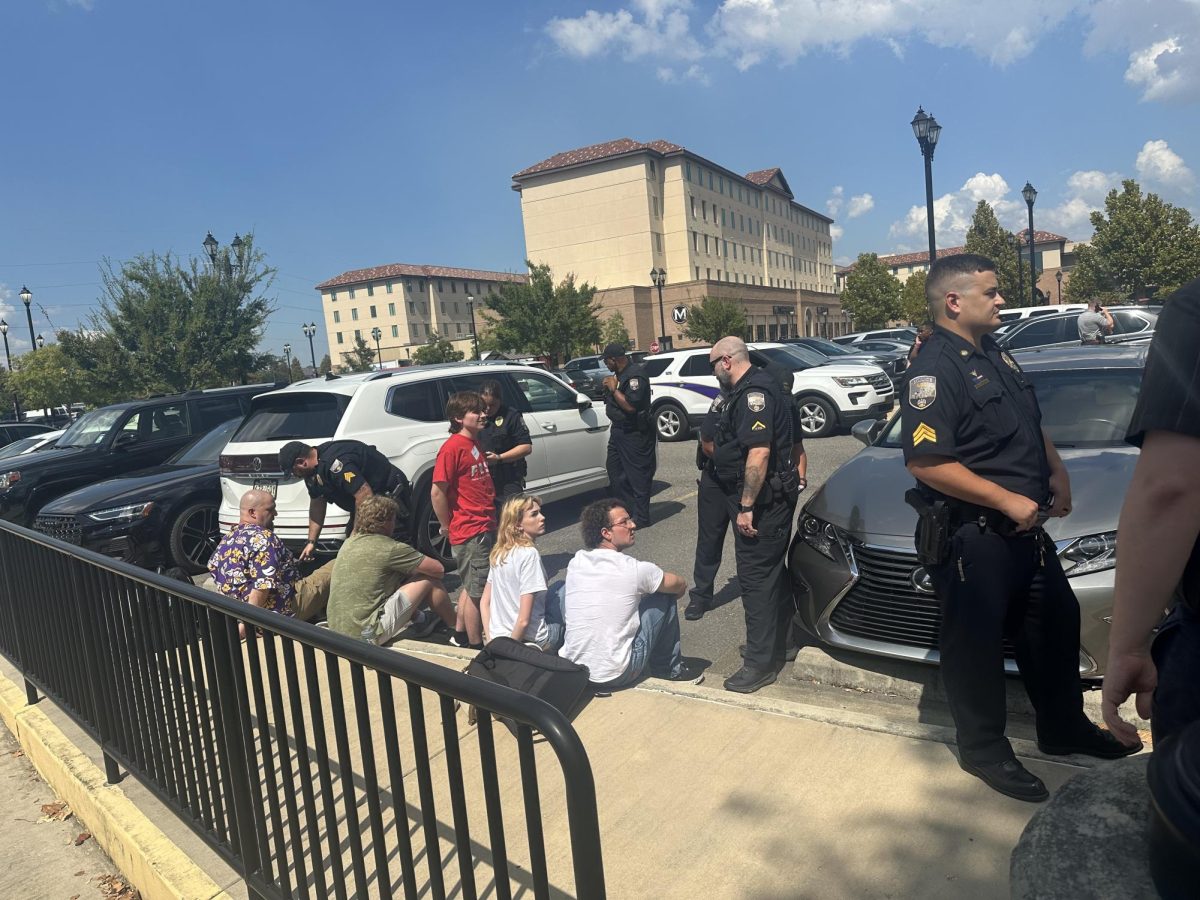 LSU students sit outside the LSU Foundation building waiting to be transferred to the police department after they were arrested. 