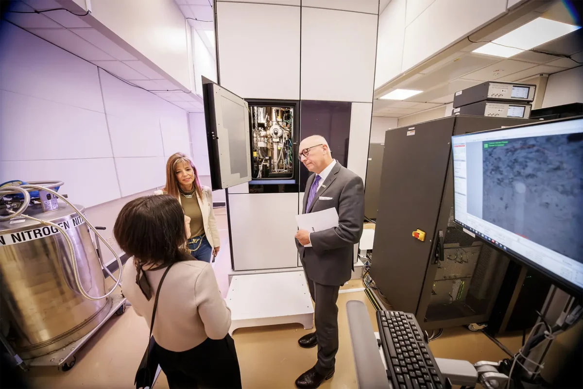 Interim LSU President Matt Lee and Supervisor Rebecca Boniol talk with AMAC Director Dongmei Cao in front of the new microscope.
