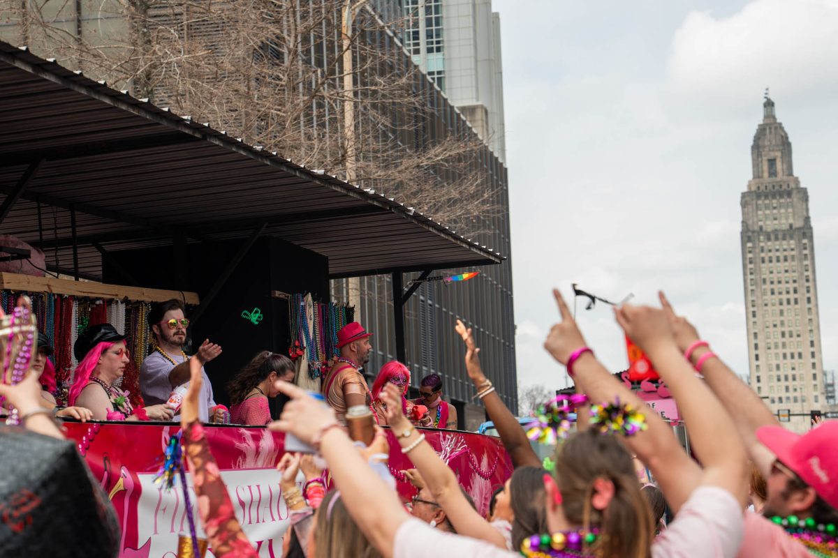 Parade-goers wave at floats during the Spanish Town parade on Saturday, Feb. 14, 2026, Downtown Baton Rouge, La.
