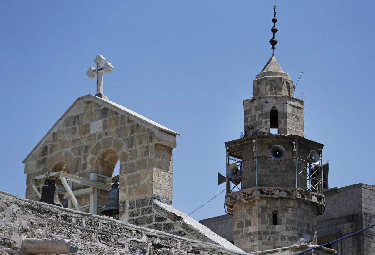 The bell tower of St. Porphyrios Greek Orthodox church, left, and the minaret of the adjacent Kateb Welaya mosque, right, are seen in Gaza City, Sunday, Aug. 10, 2014.