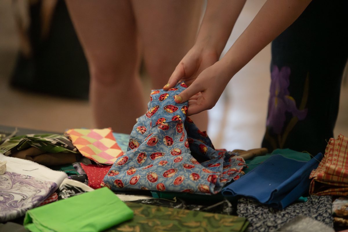LSU Fashion Association student holds fabric  Thursday, March 26, 2026, at the LSU Textile and Costume Museum in Baton Rouge, La.