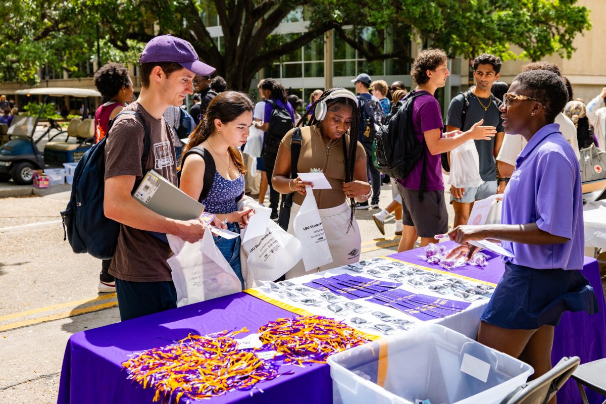 A Greek Life table attendant speaks with students during the Student Wellness Fair on Friday, April 10, 2026, on Tower Drive in Baton Rouge, La.